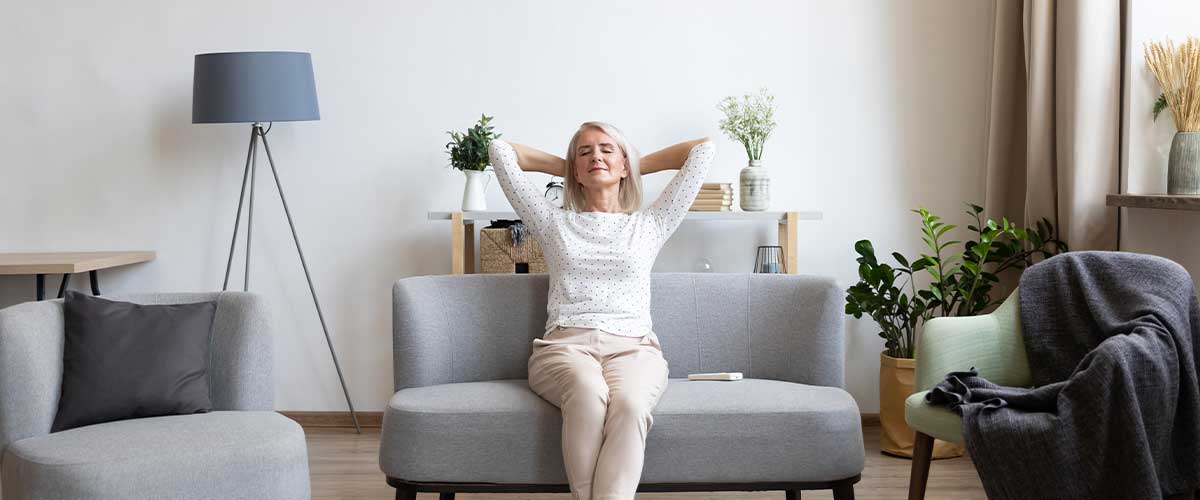 a senior woman relaxing in the living room of her senior living apartment