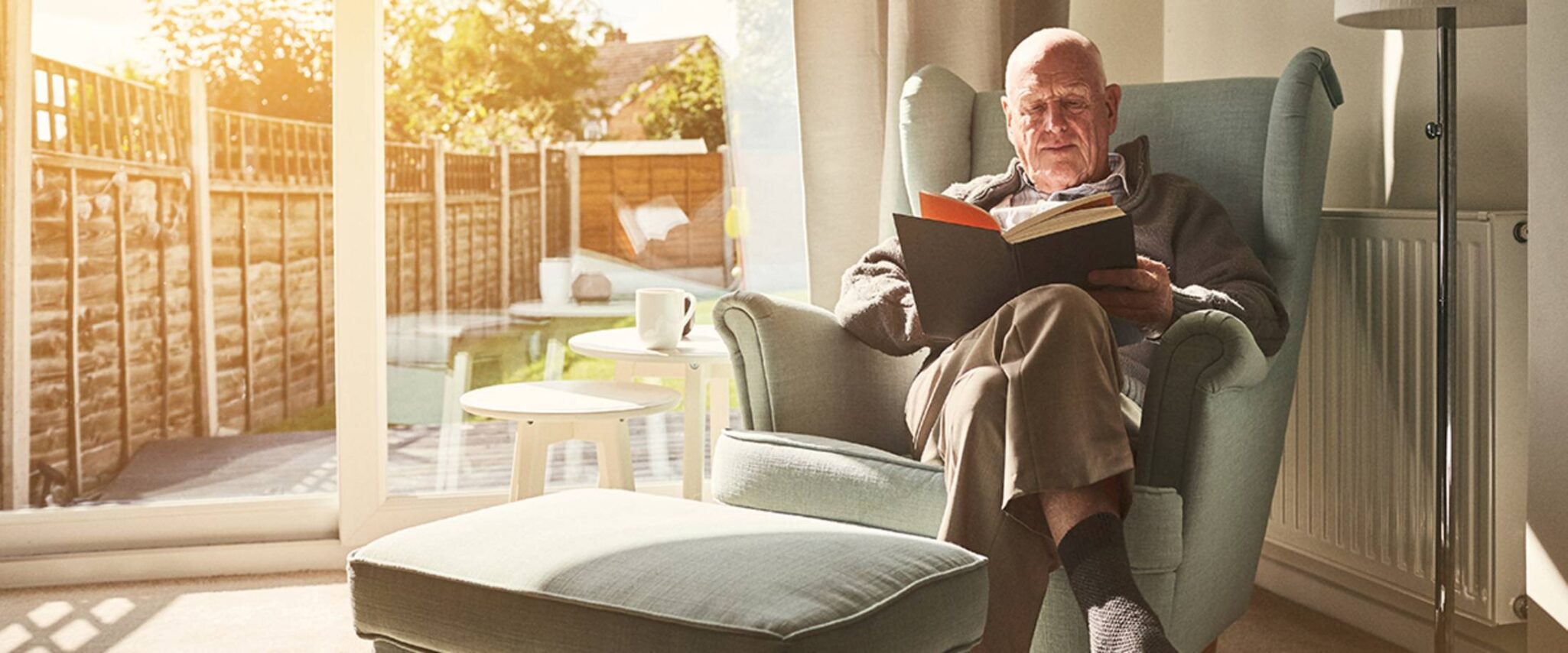 senior reading a book in a chair