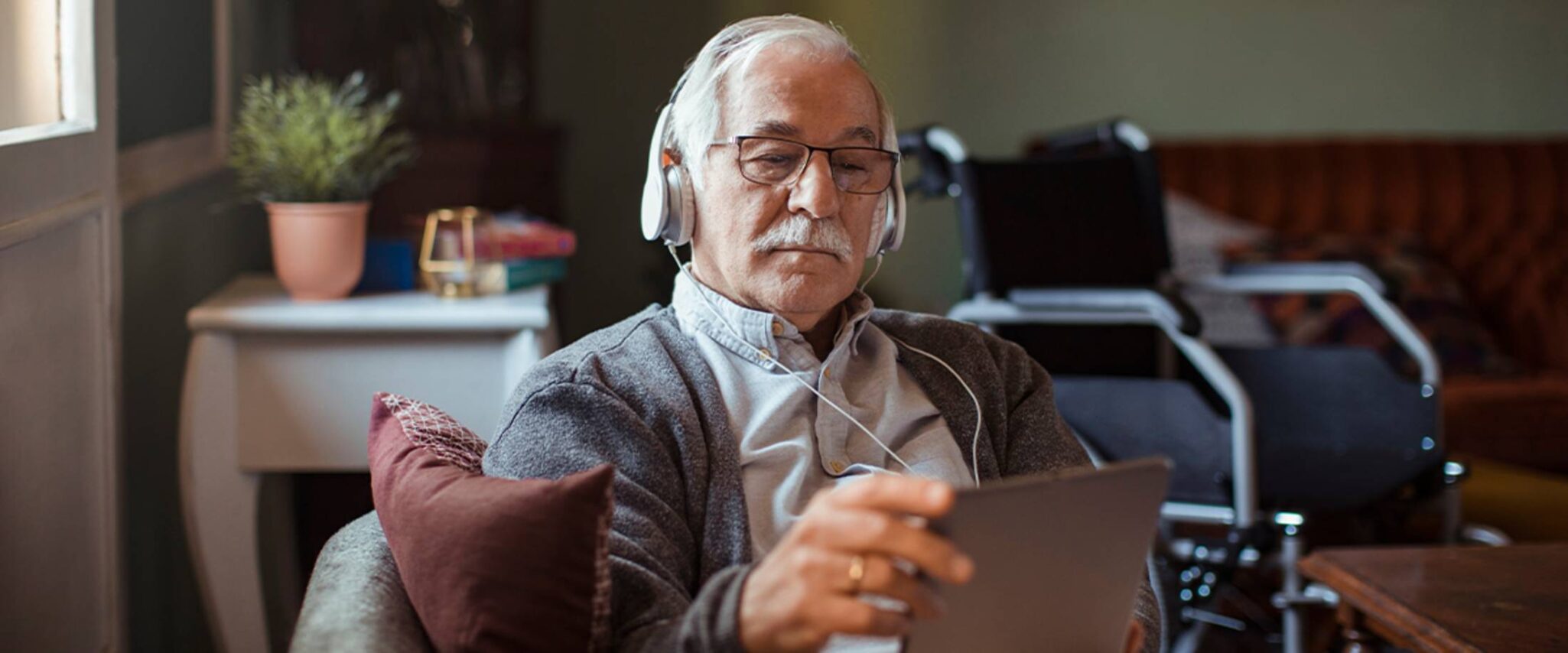 senior man listening to a podcast on his smart device