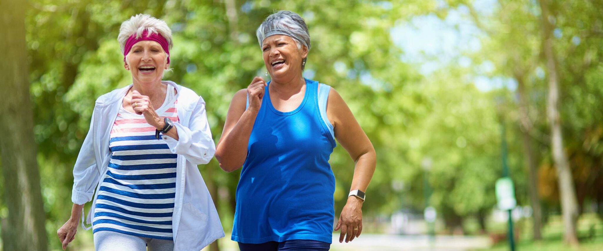 two senior women walking in a park on a sunny day