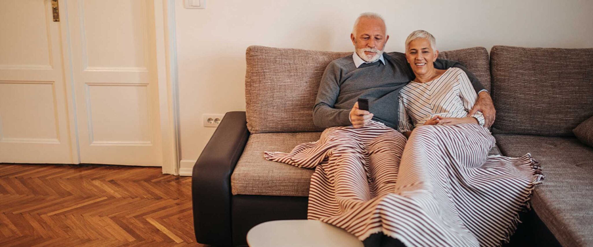 senior couple watching a movie on the couch