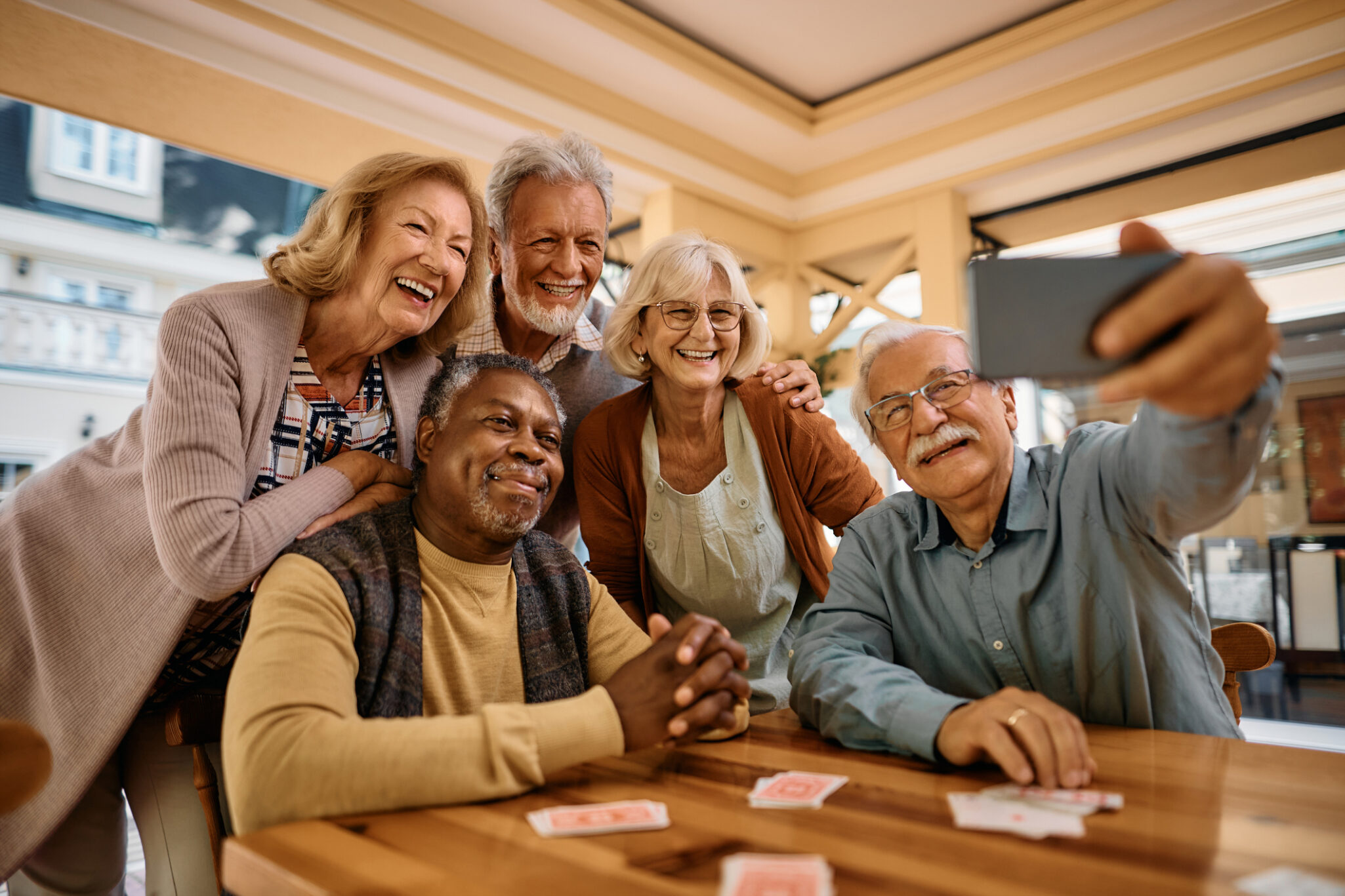 A group of older adults smiling for a group selfie