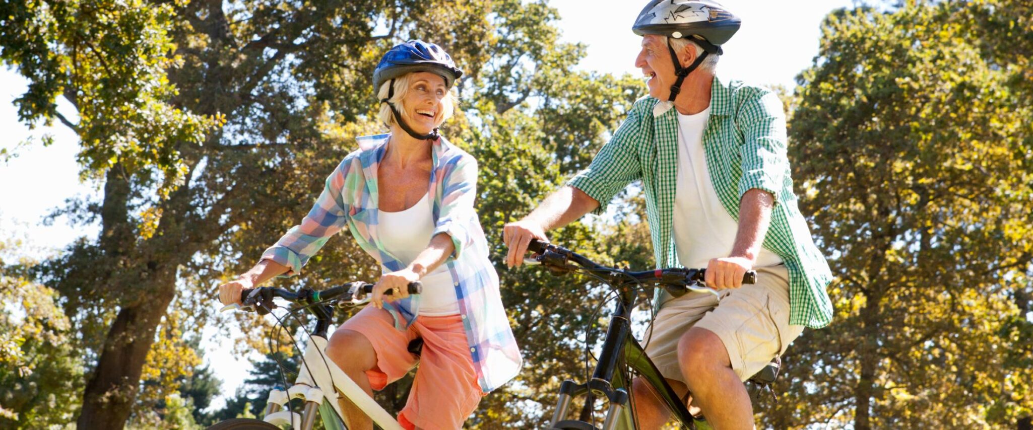 senior couple riding bikes on a trail