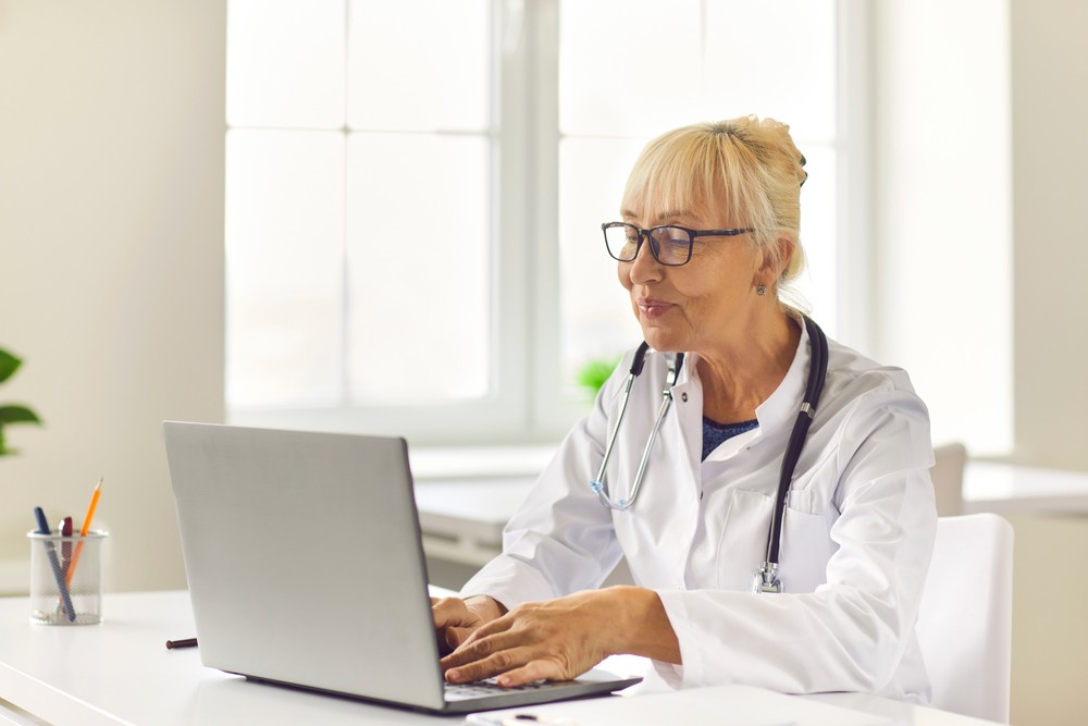 Experienced female senior healthcare worker using her laptop