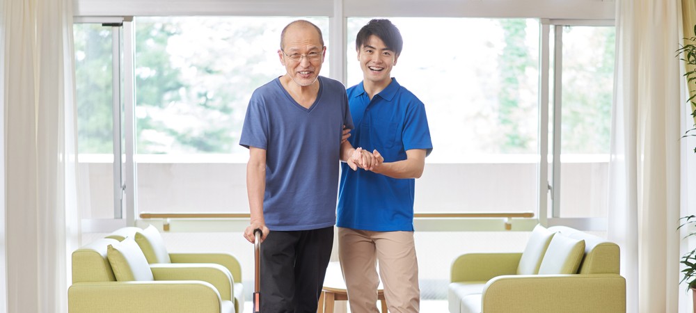 Male caregiver assisting his father