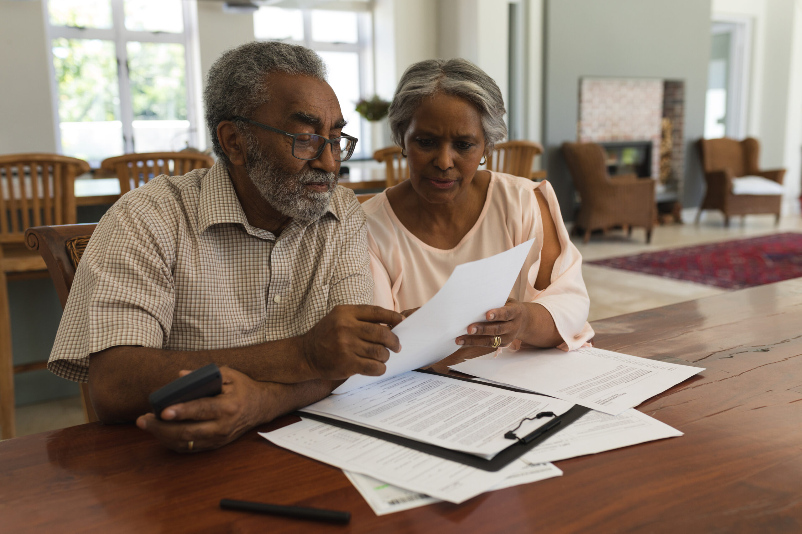 Senior couple discussing over invoices at home