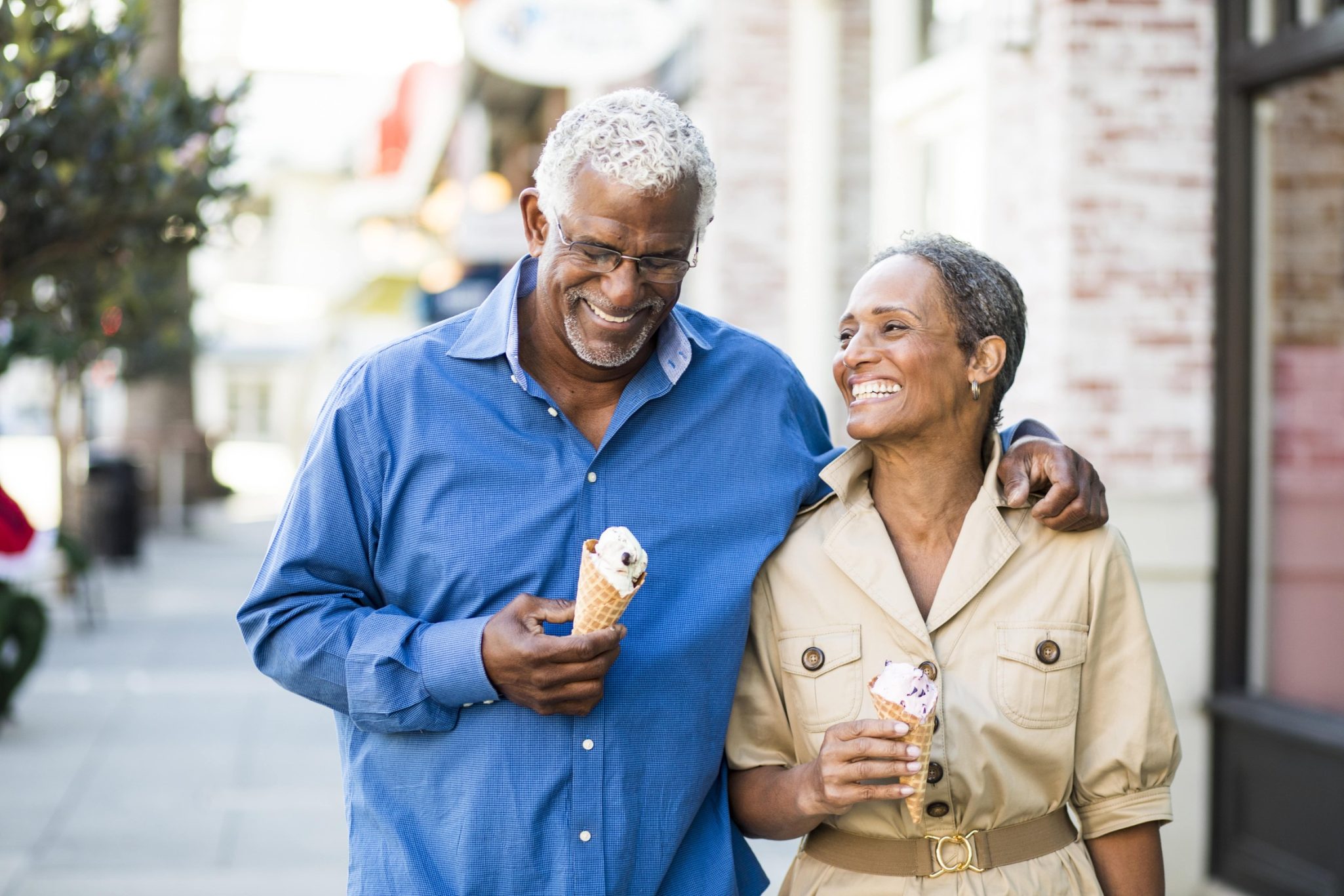 Smiling senior couple on walk while holding ice cream